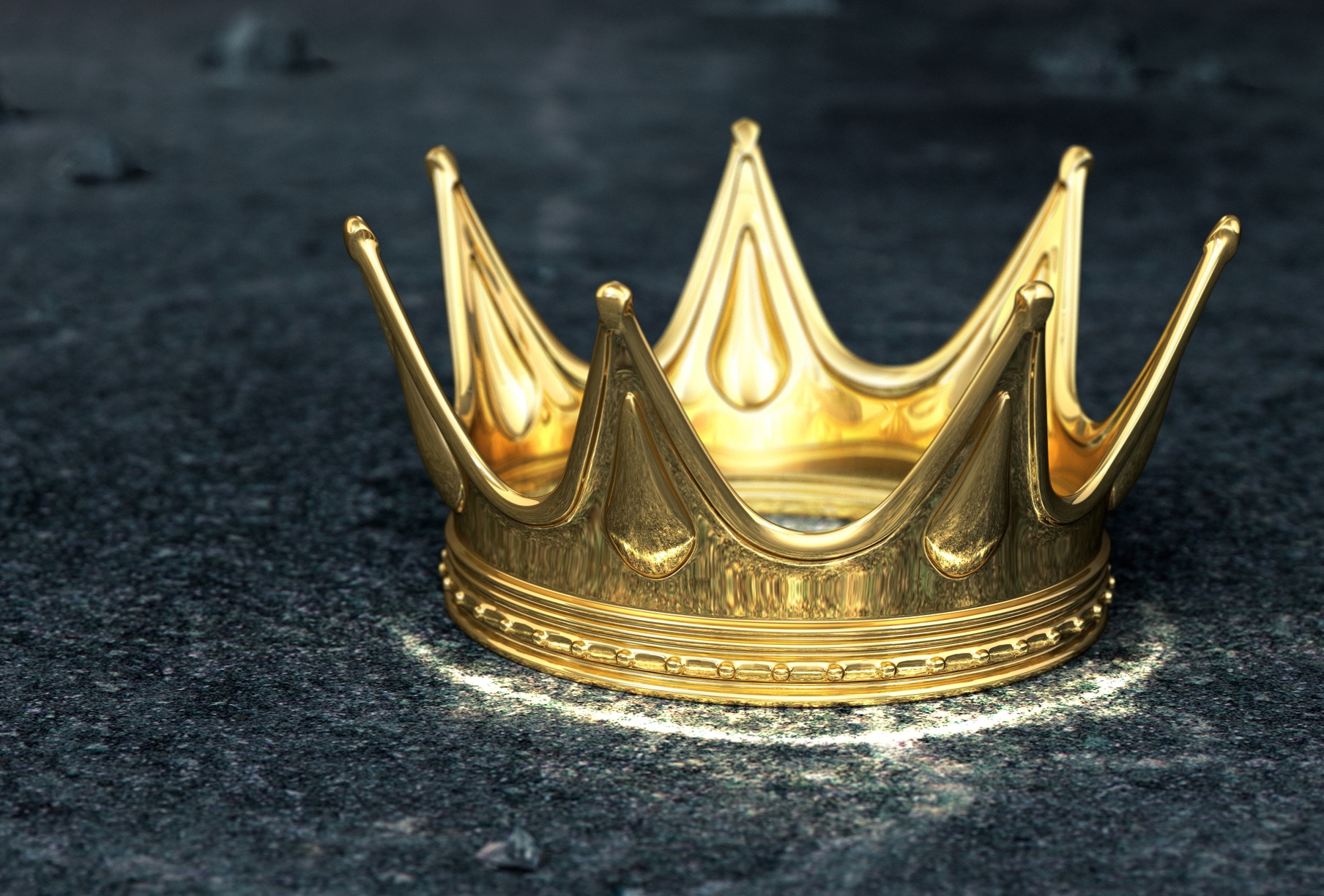 Gold crown laying on a dark grey surface