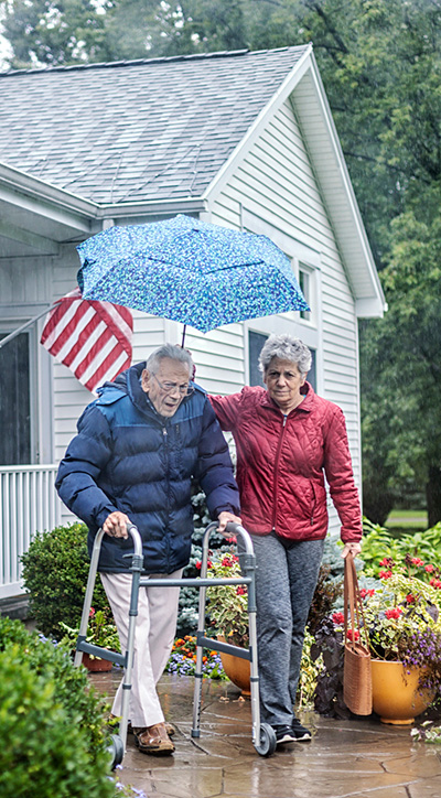 GettyImages-1071595354-vertical Elderly woman and man walking together in the rain