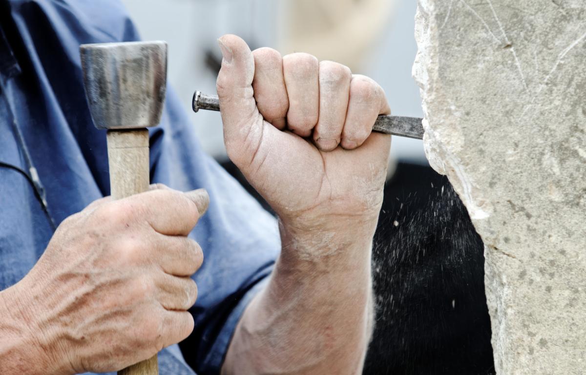 closeup of man's hands working on a sculpture