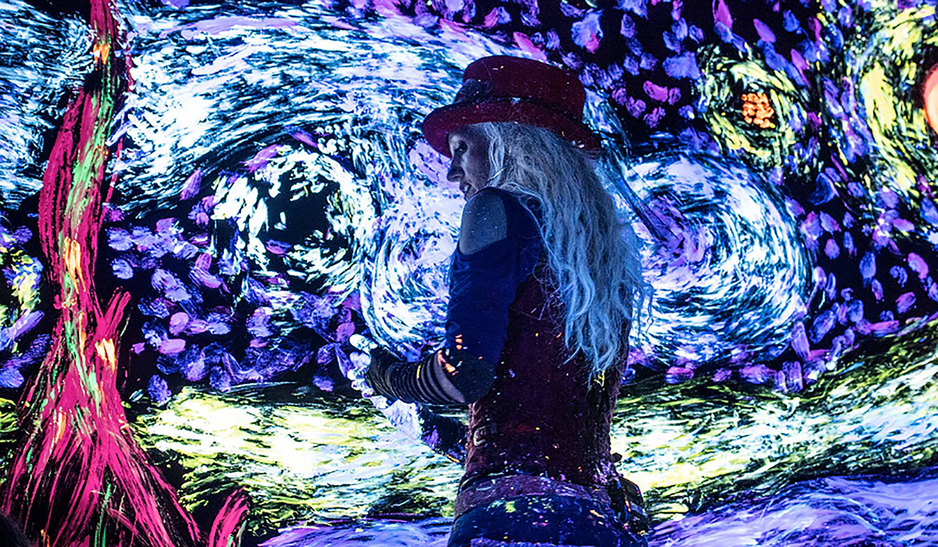 Performer dressed in dark colors with lighted starry night background