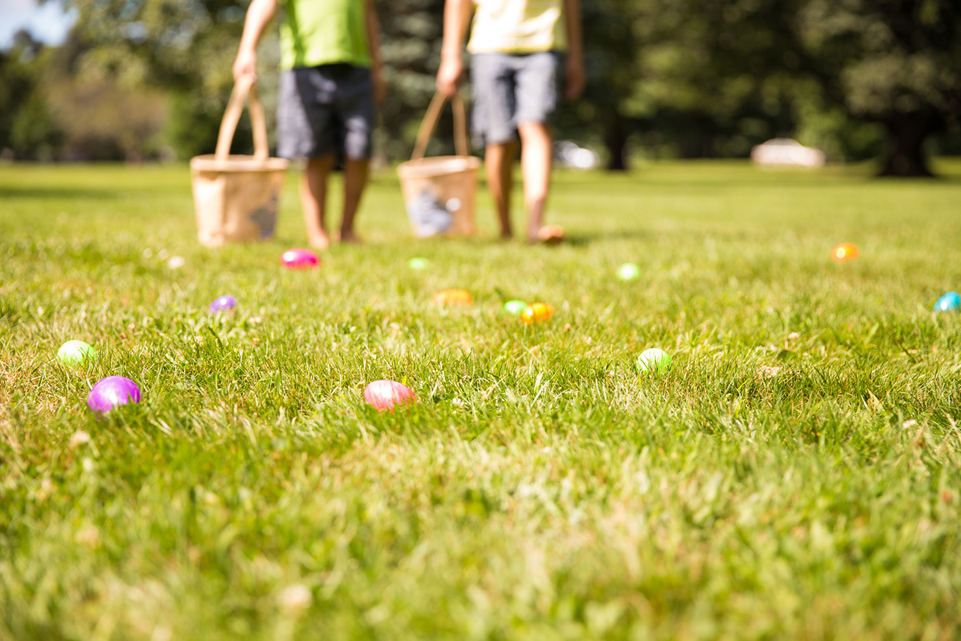 Closeup of Easter Eggs in grass with children in the background