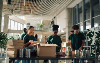 Group of volunteers preparing donations in a large room.