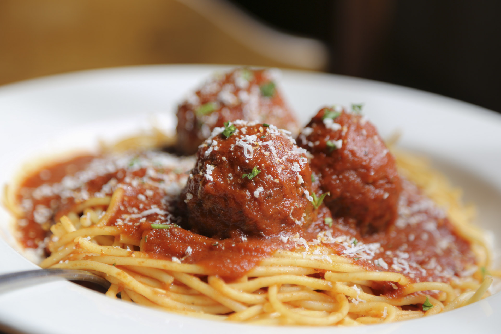 Closeup of a plate of spaghetti and meatballs on a white plate.